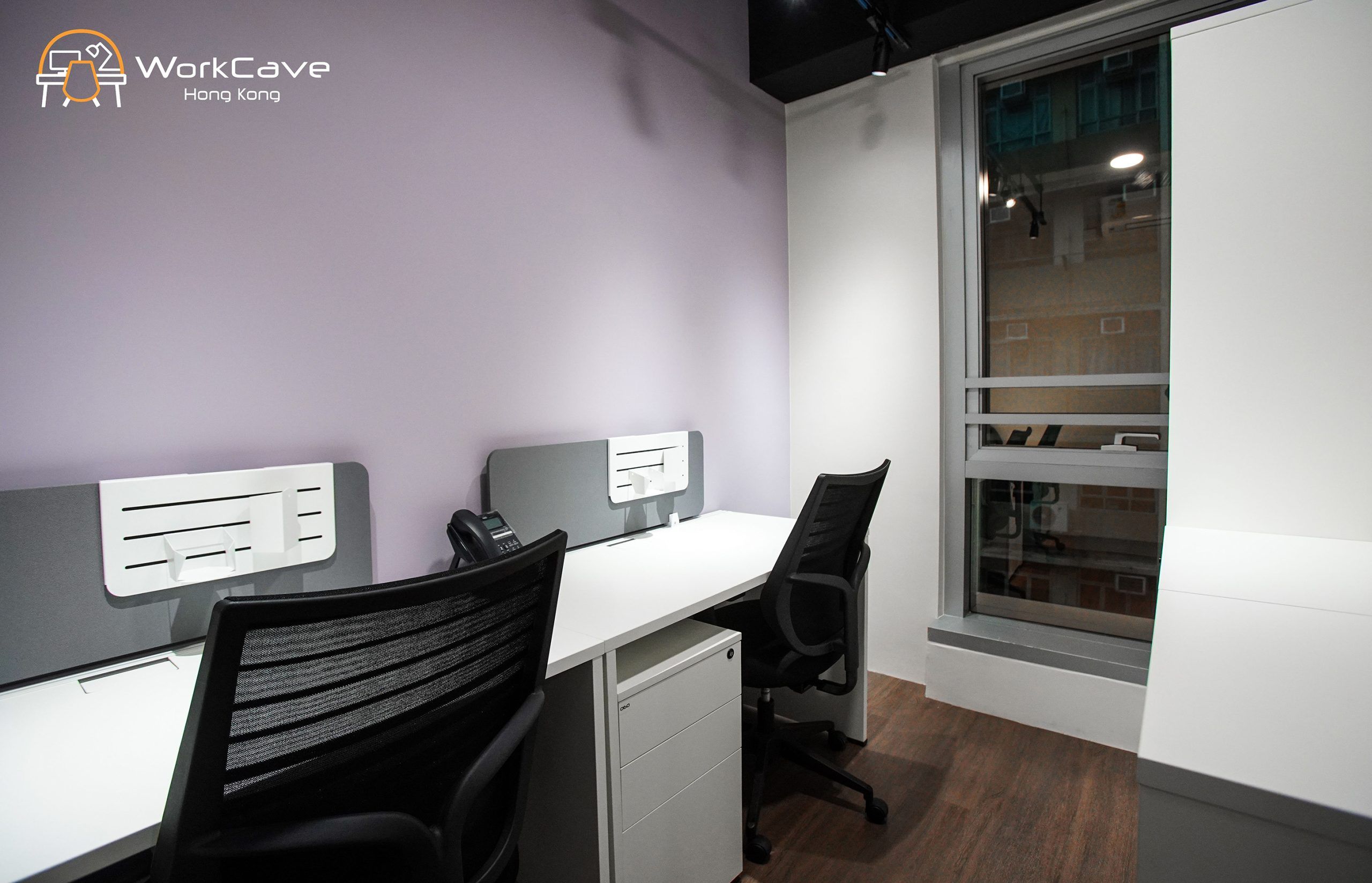 WorkCave 2-pax office, building view, tables and chairs facing purple wall