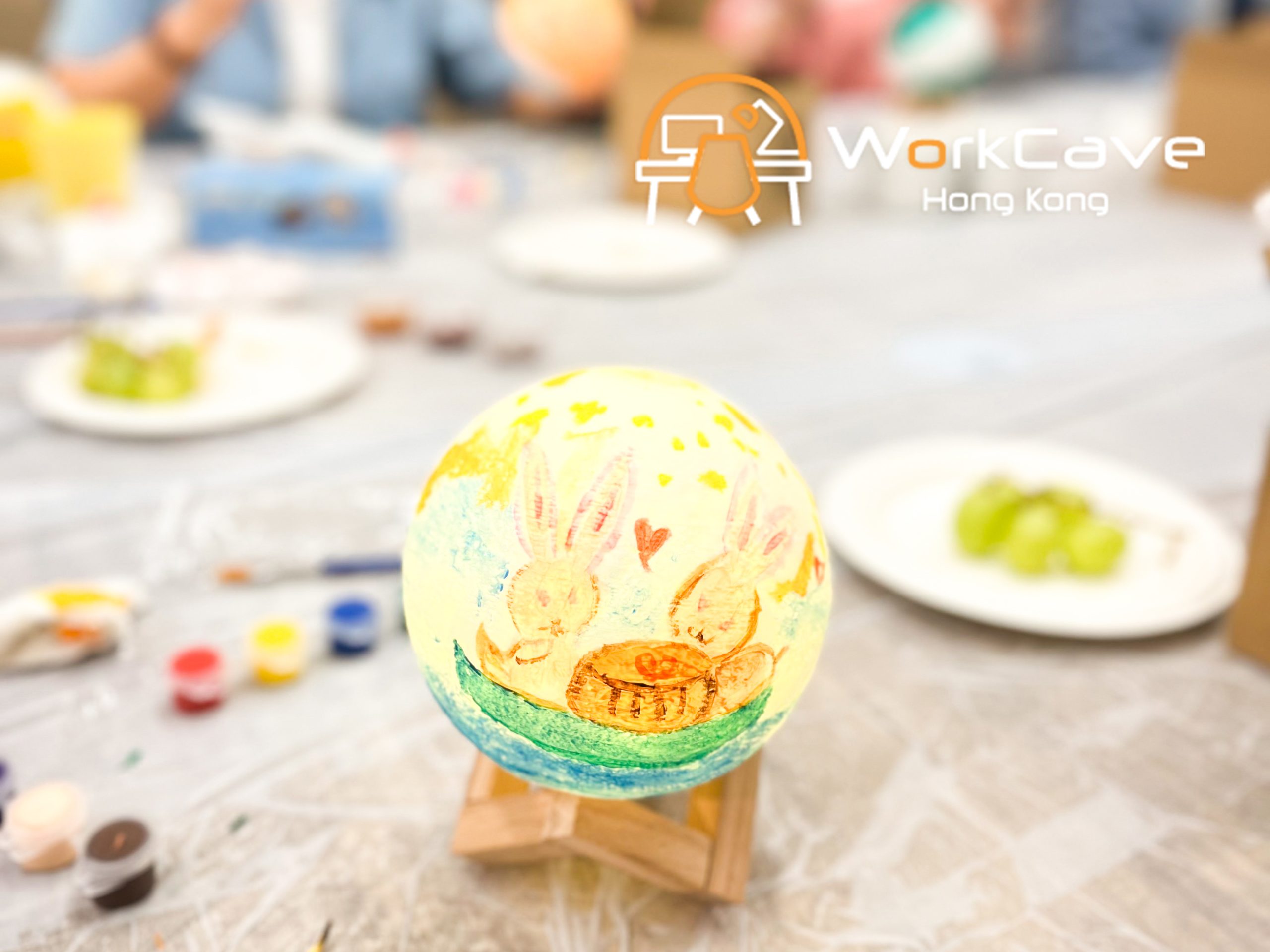 A close up to one of the moon lamps painted two rabbits enjoying a big mooncake on a boat under the starry sky